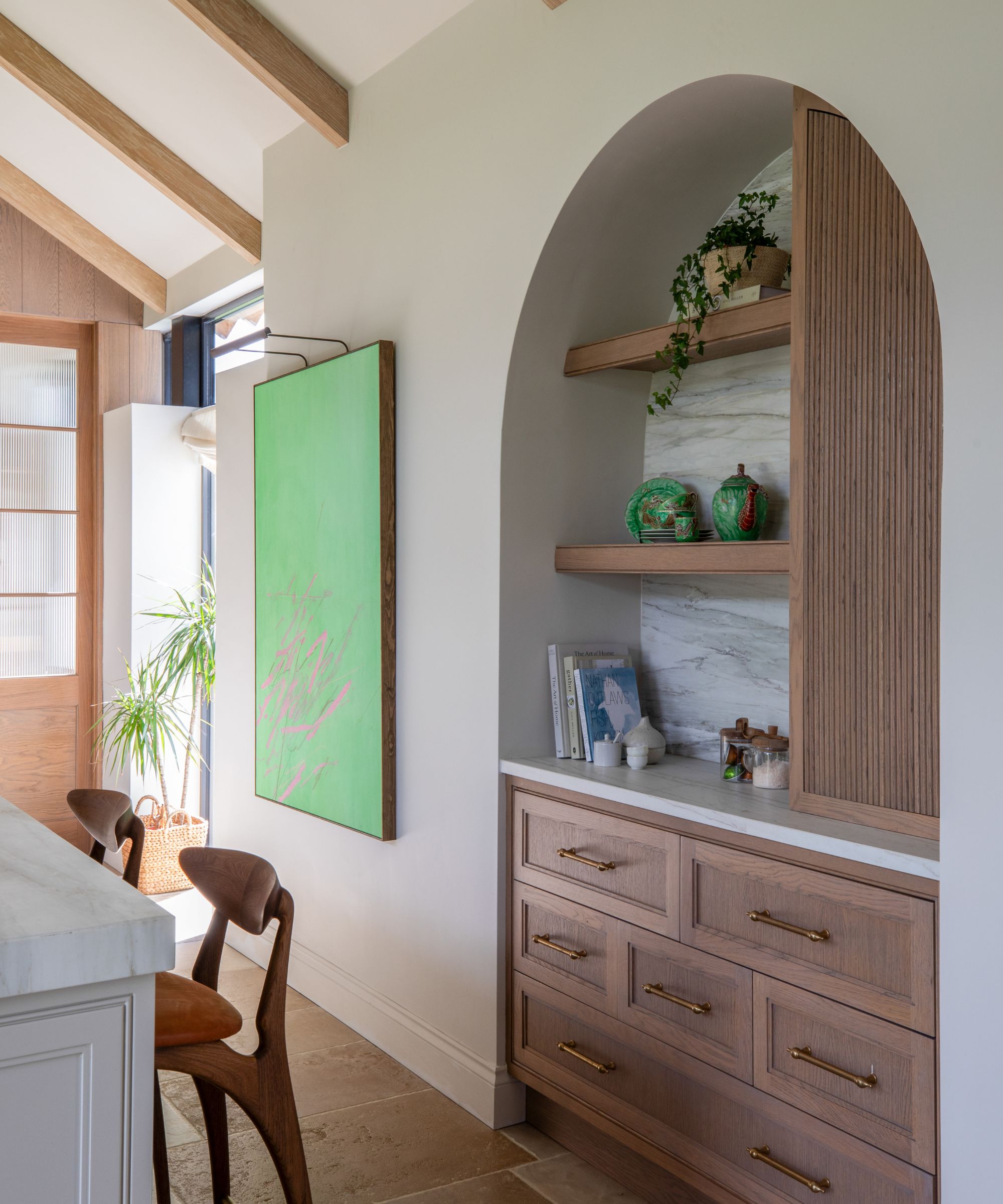 A wood and white kitchen with a recessed arch alcove used as a coffee station