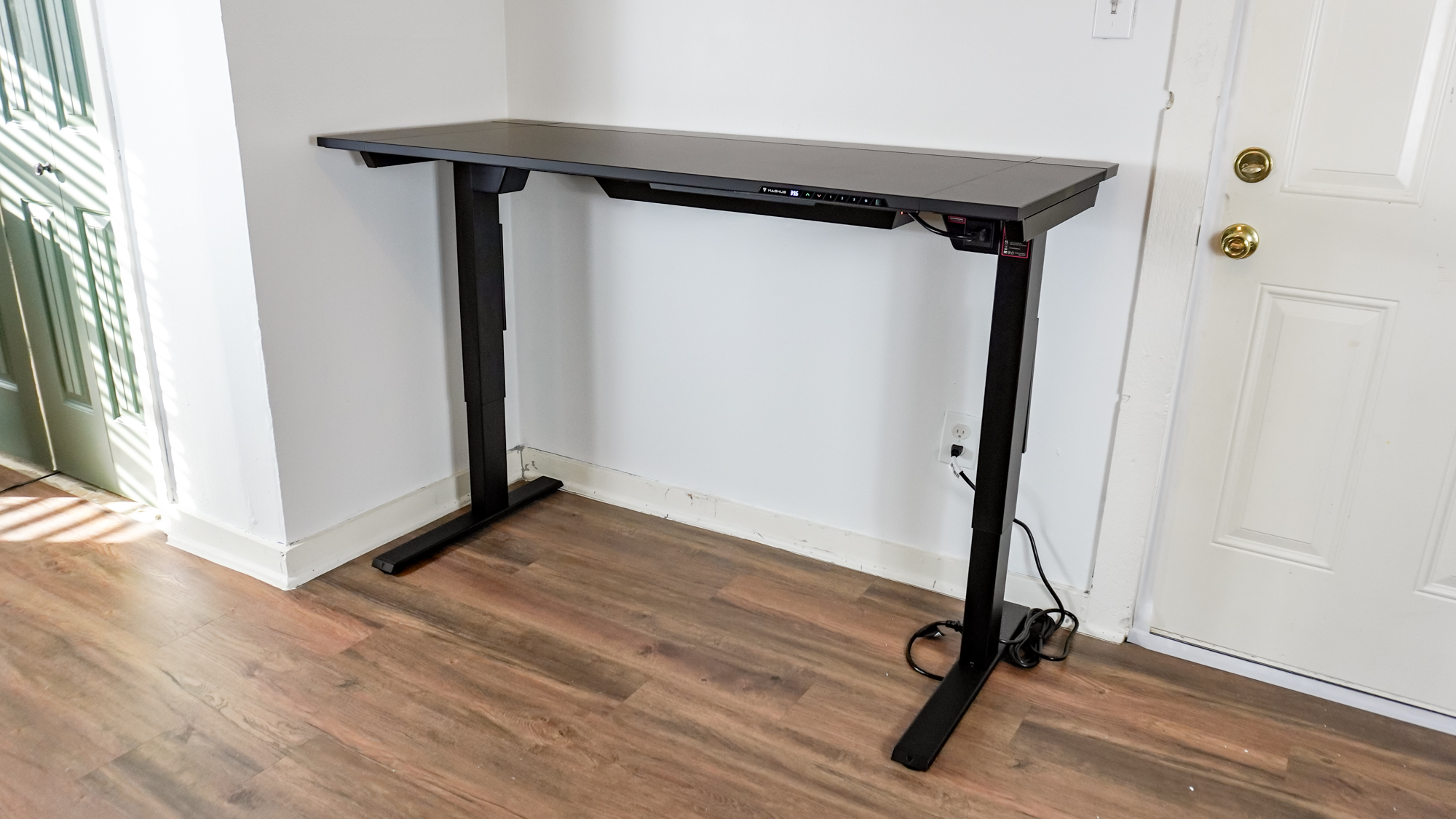 The Secretlab Magnus Evo standing desk raised up against a wall