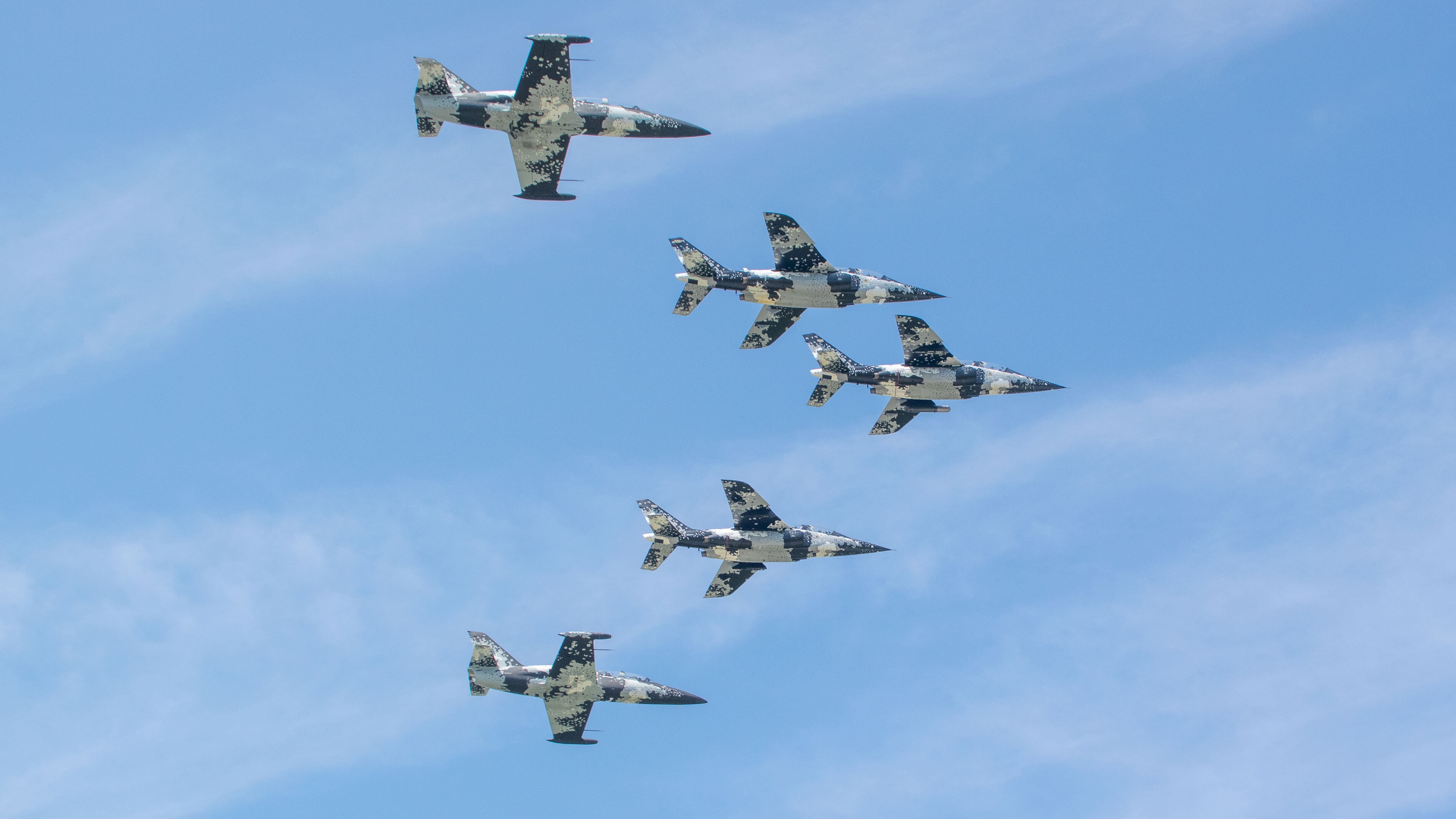 NASA Space Technology Five jets fly in formation in a blue sky.