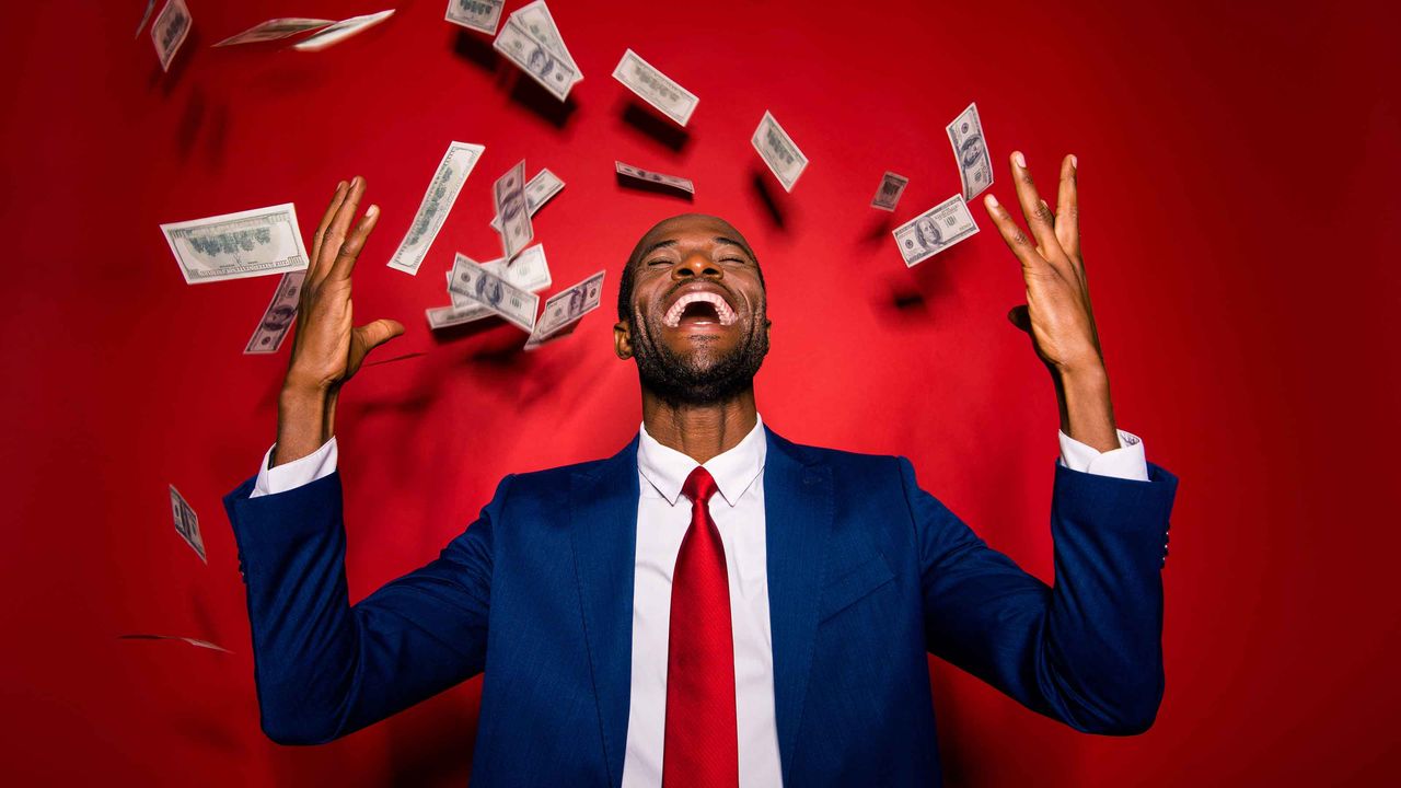 Photo of a man throwing money up in the air in celebration