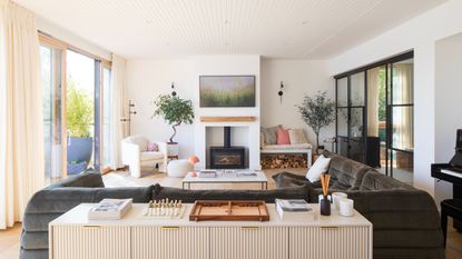 Log burner underneath TV, next to built in bench storing logs underneath