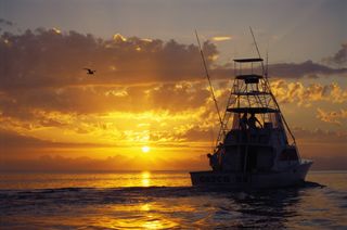 A boat filled with sport fishermen at sunrise in the Florida Keys