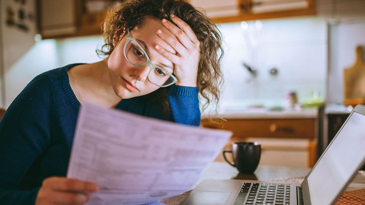 Woman going through bills © Getty Images