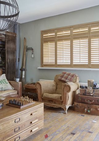 old chair in living room with vintage suitcases wooden floorboards art drawers coffee table