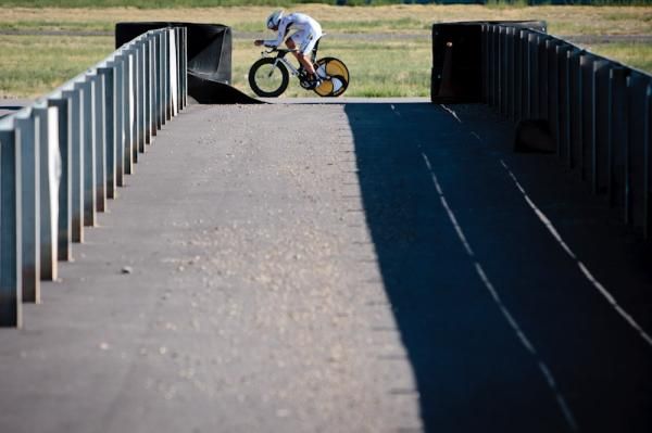 An HTC-Highroad rider passes by barriers along the race track.