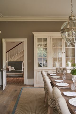 Beige rug with blue trim in beige dining room