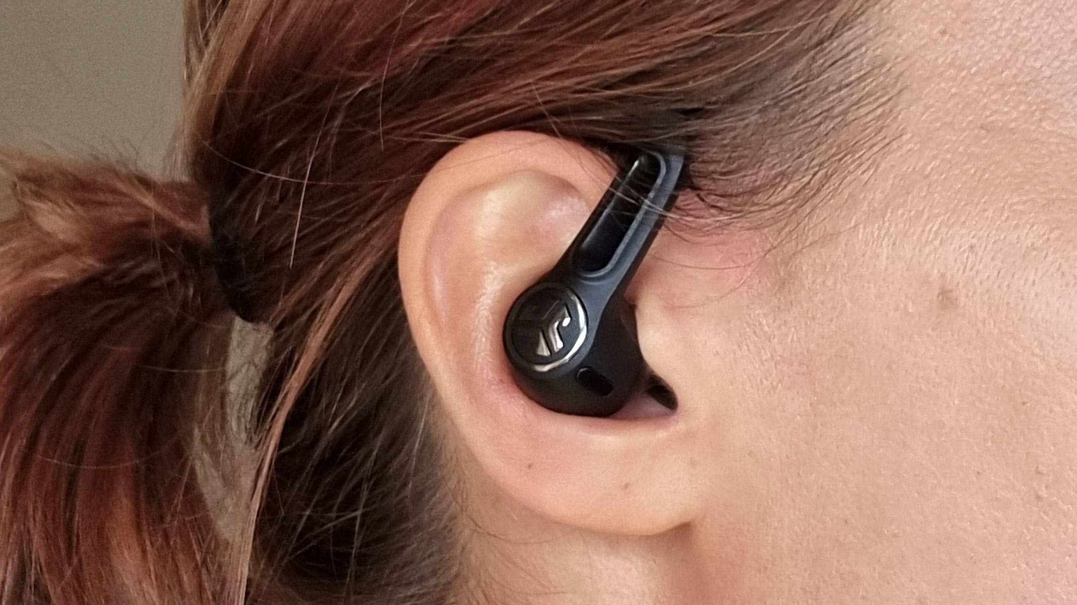 a close-up picture of our reviewer testing the JLab Epic Sport ANC 3 earbuds