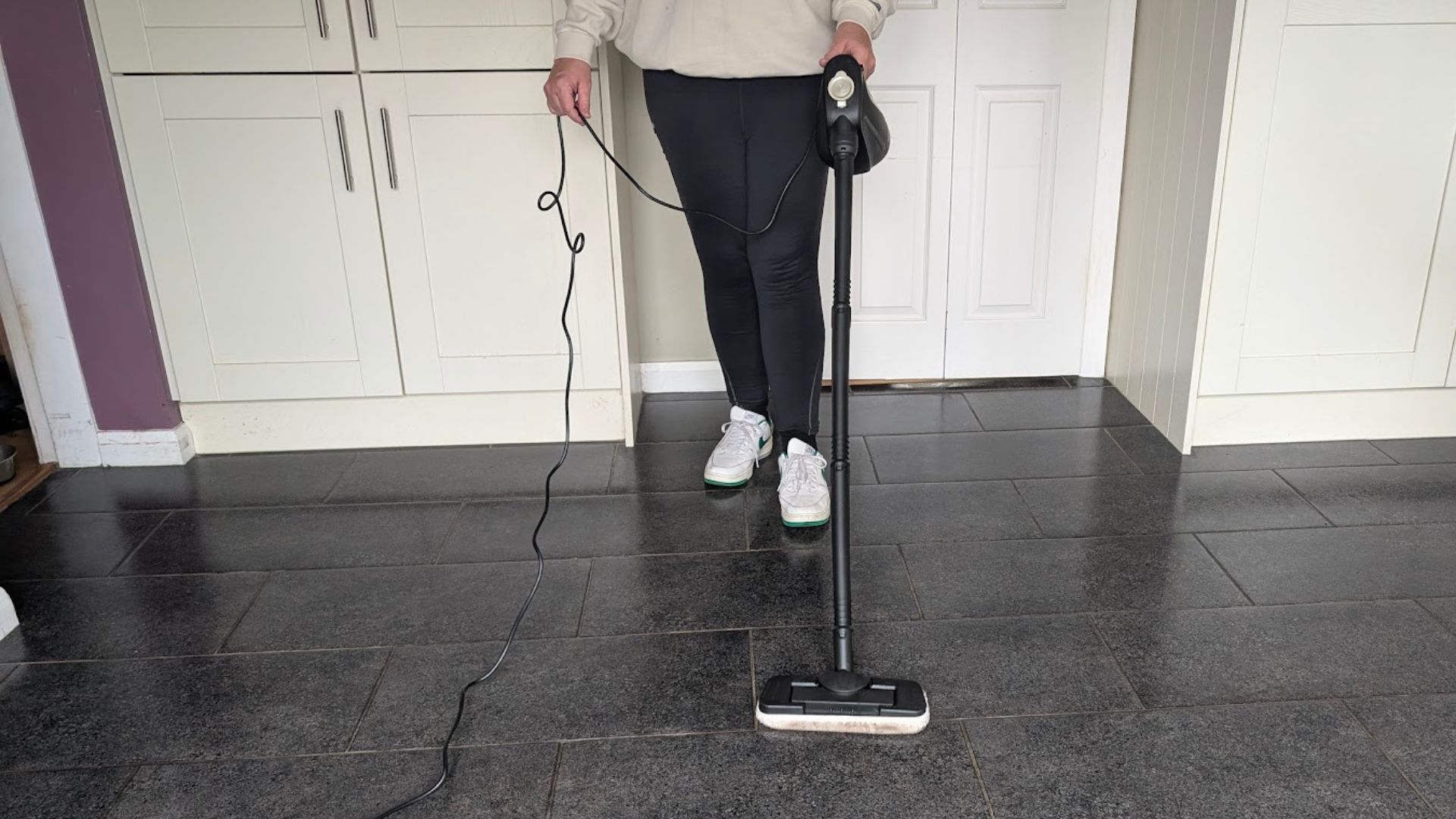 Testing the Beldray 15-in-1 Steam Cleaner cleaning a kitchen floor with our tester using it