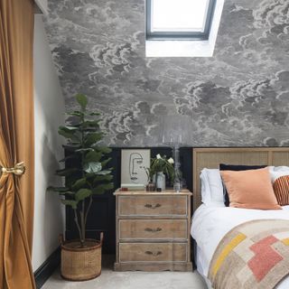 Grey wallpaper on bedroom wall with wooden furniture