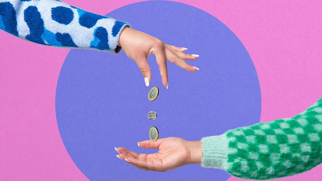 A hand dropping coins into another hand 