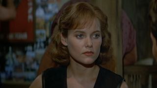 Carey Lowell glares while sitting in a bar in License to Kill.