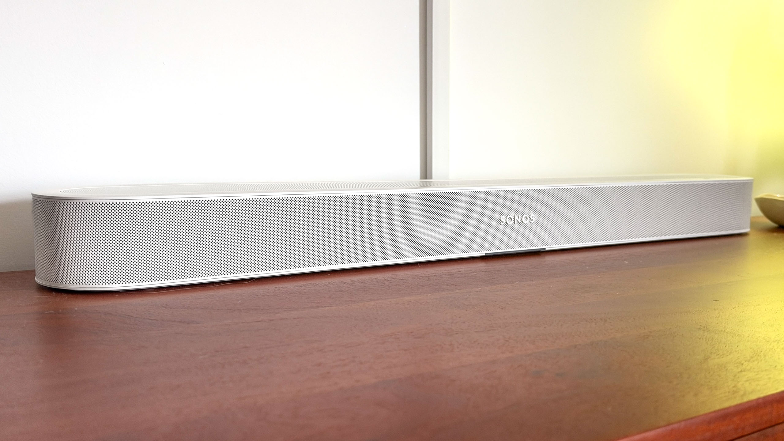 A Sonos Beam Ultra soundbar on a side table