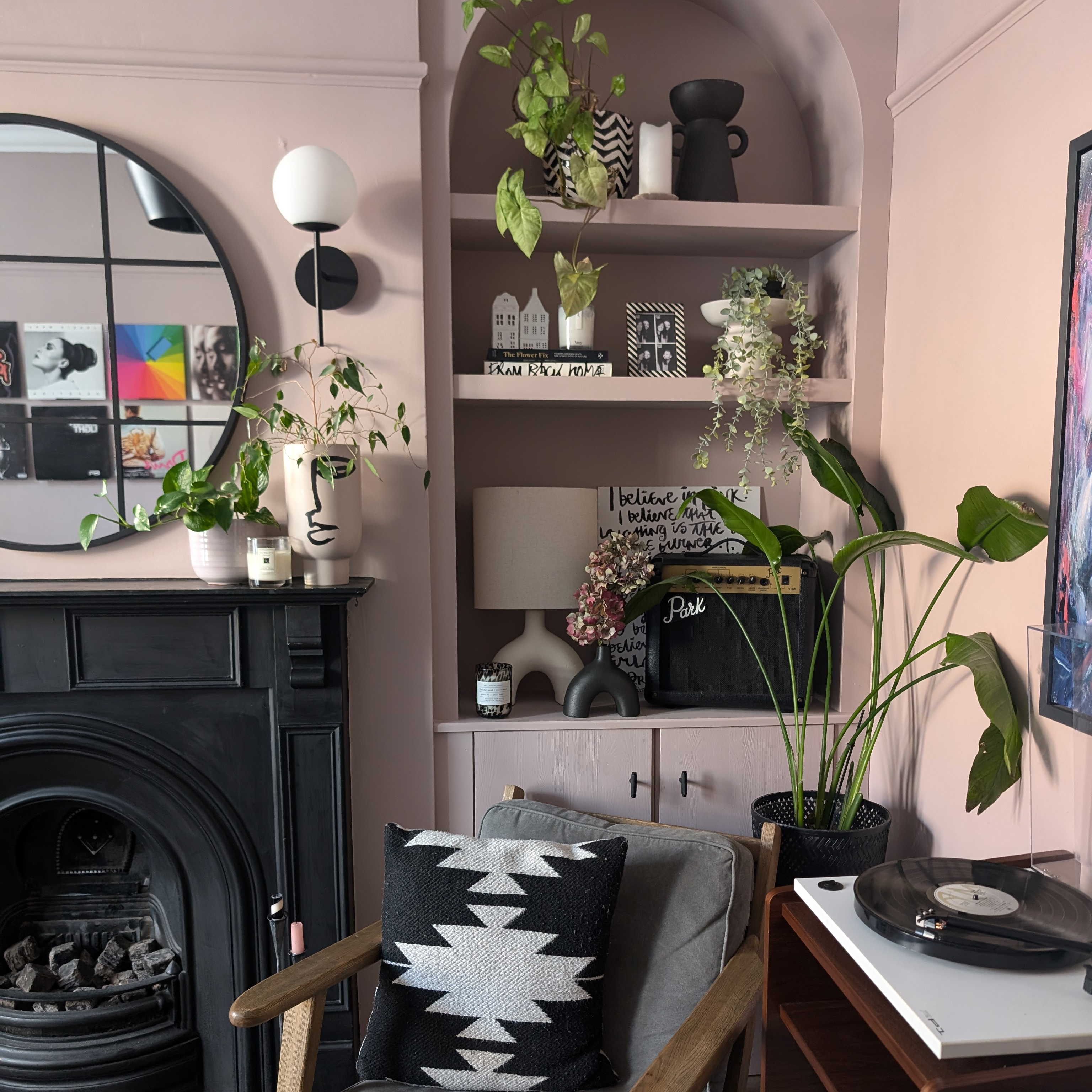 pink living room with shelf of vases and plants