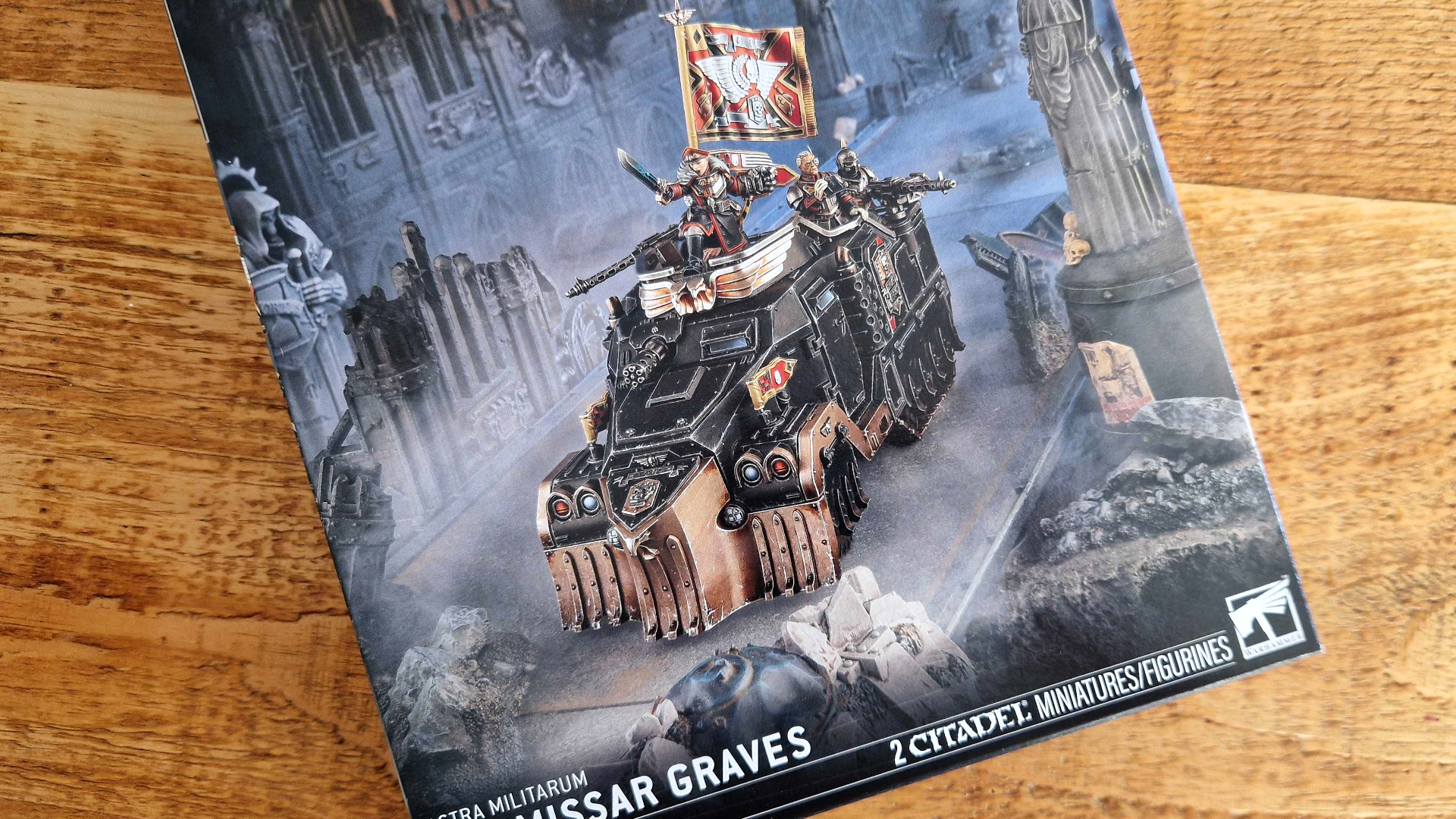Commisar Graves box displaying artwork of an armored vehicle on a wooden table