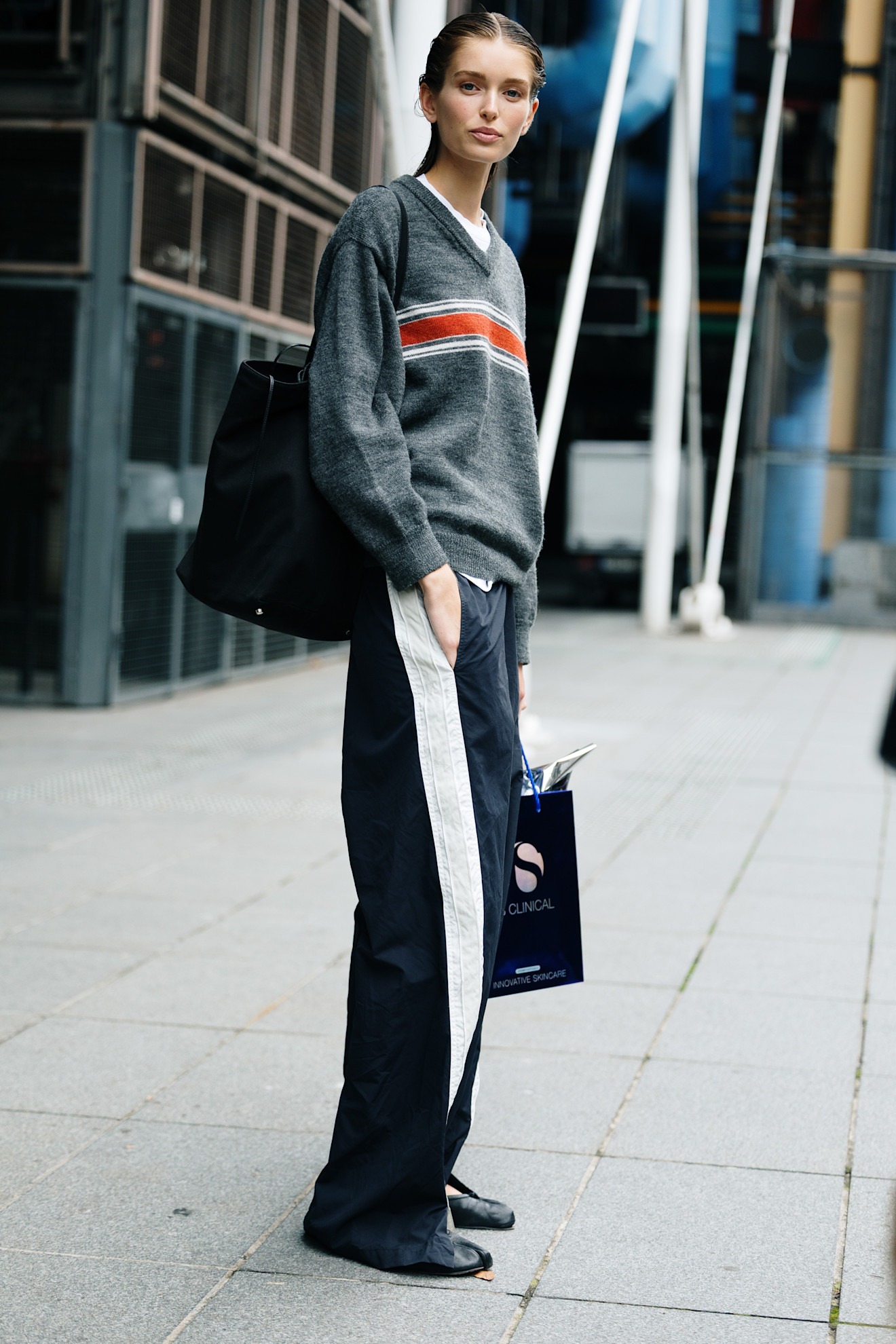 fashion week attendee wearing grey striped sweater and track pants