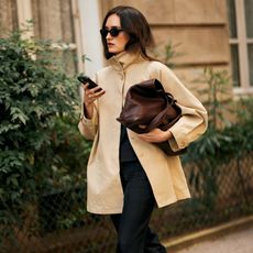 woman wearing tan jacket, bag, and black pants