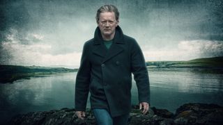 DI Jimmy Perez (Douglas Henshall) stands on the Shetland coastline, with an charcoal-y fade effect at the borders of the image
