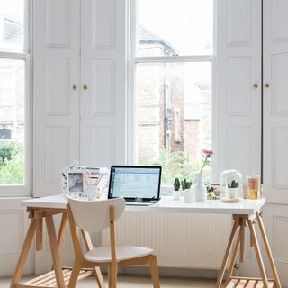 Desk area in front of windows with wooden shutters