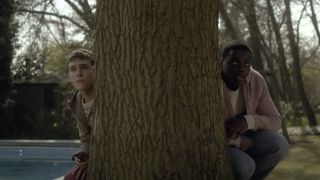 Paul and MIchael peeking from behind a large tree in The Fades