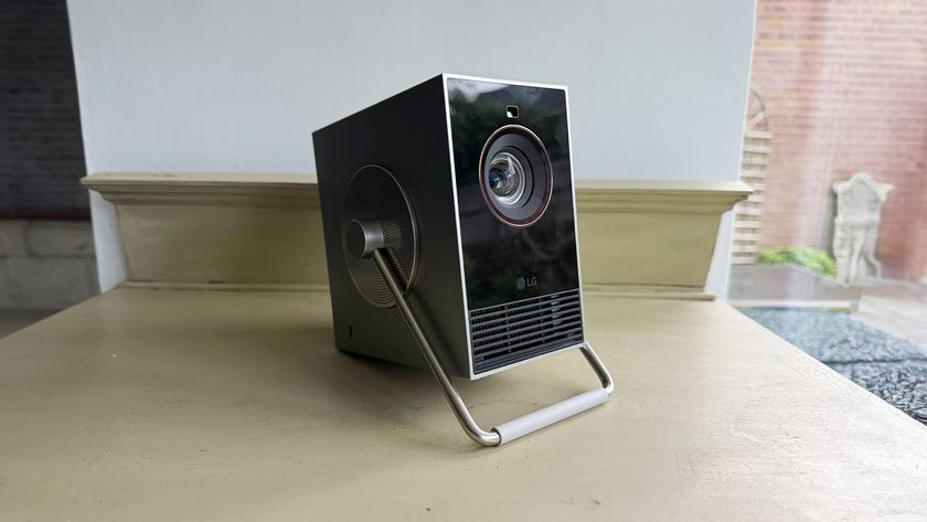 LG CineBeam Q ultra portable projector tilted slightly upwards on wooden shelf