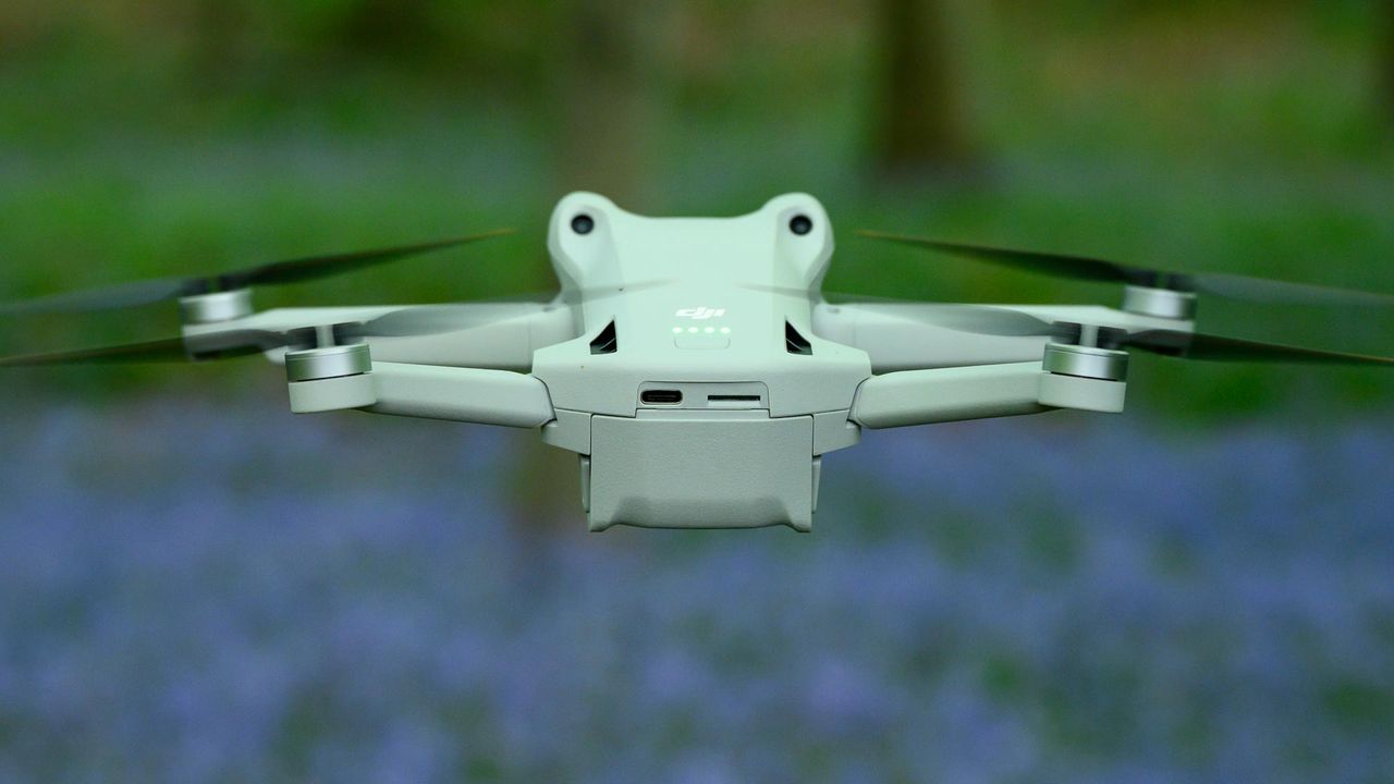 DJI Mini 3 Pro flying in a forest with bluebells