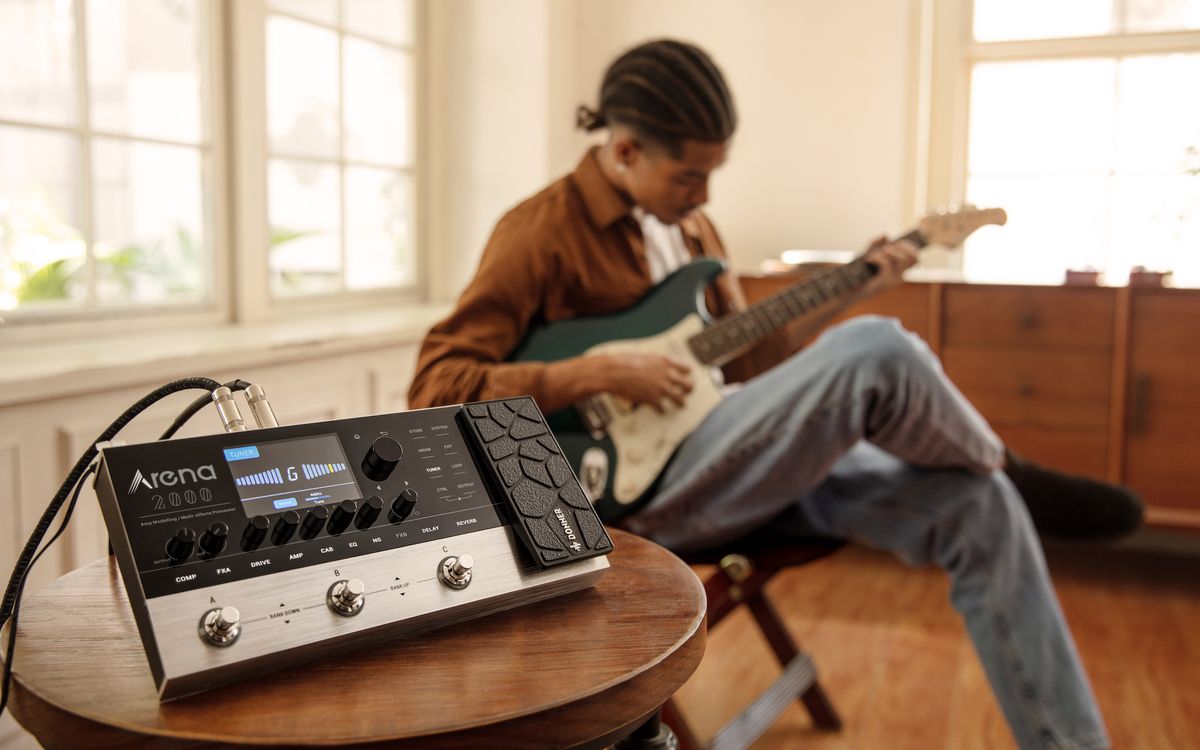 A guitarist uses Donner's Arena2000 mutli-effects unit