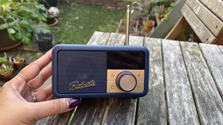 Roberts Revival Petite 2 internet radio in hand on garden table