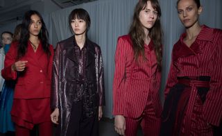 Models wear red suits and purple crocodile patterned trench coat