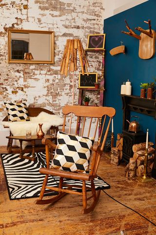 cosy living room with blue wall, a rocking chair, animal print rug and geometric cushions