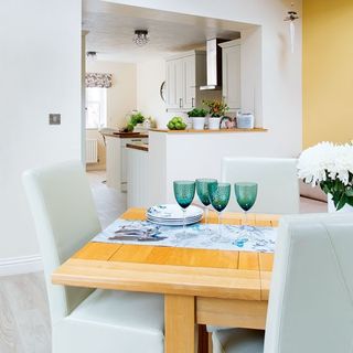 dining space with table and chairs and glassware