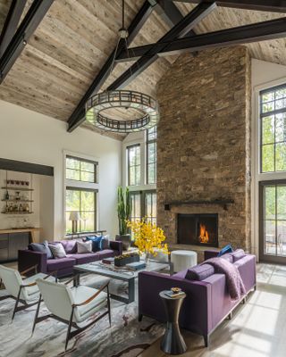 purple sofas and grey armchairs in tall ceiling