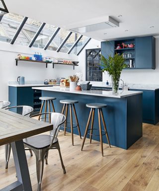 L-shaped kitchens example in blue with sky lights and white walls.