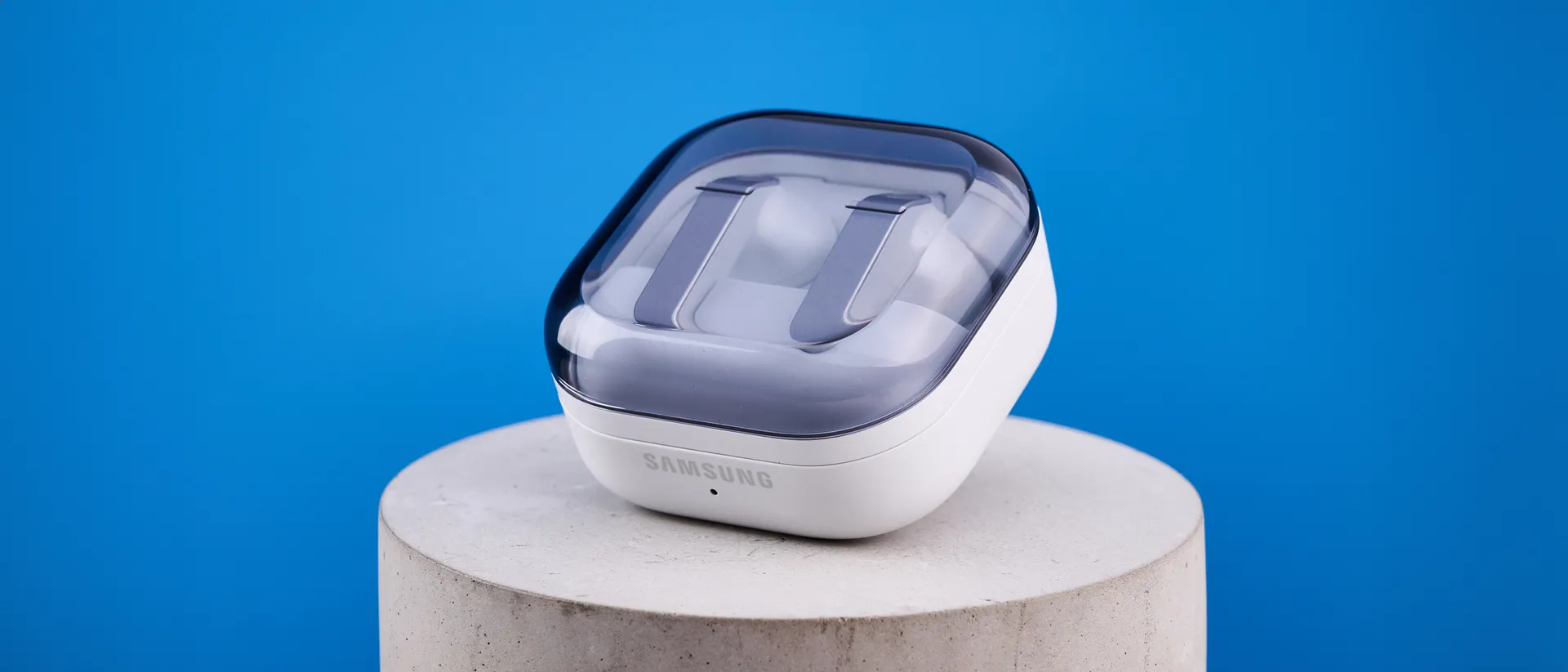 A pair of white Galaxy Buds4 Pro hover with the left earbud slightly lower than the right.