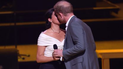 Prince Harry and Meghan Markle kiss onstage