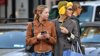 Lila Moss in lower manhattan wearing a suede jacket and a pair of wide leg jeans