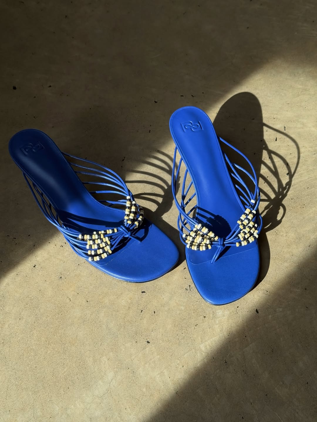 a pair of beaded blue sandals