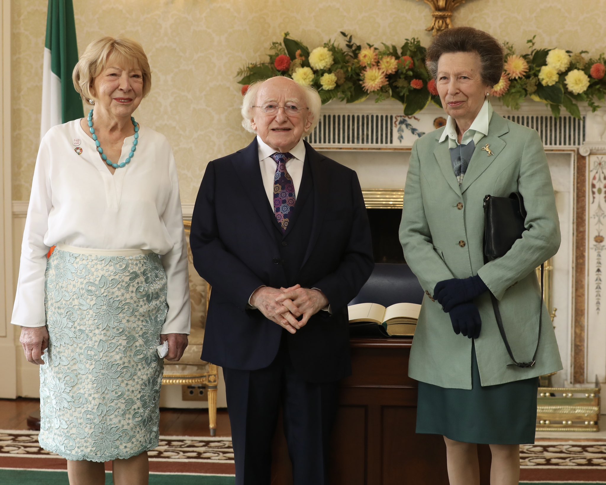 Princess Anne wearing a green blazer standing with the President of Ireland, Michael D. Higgins, and his wife Sabina Higgins