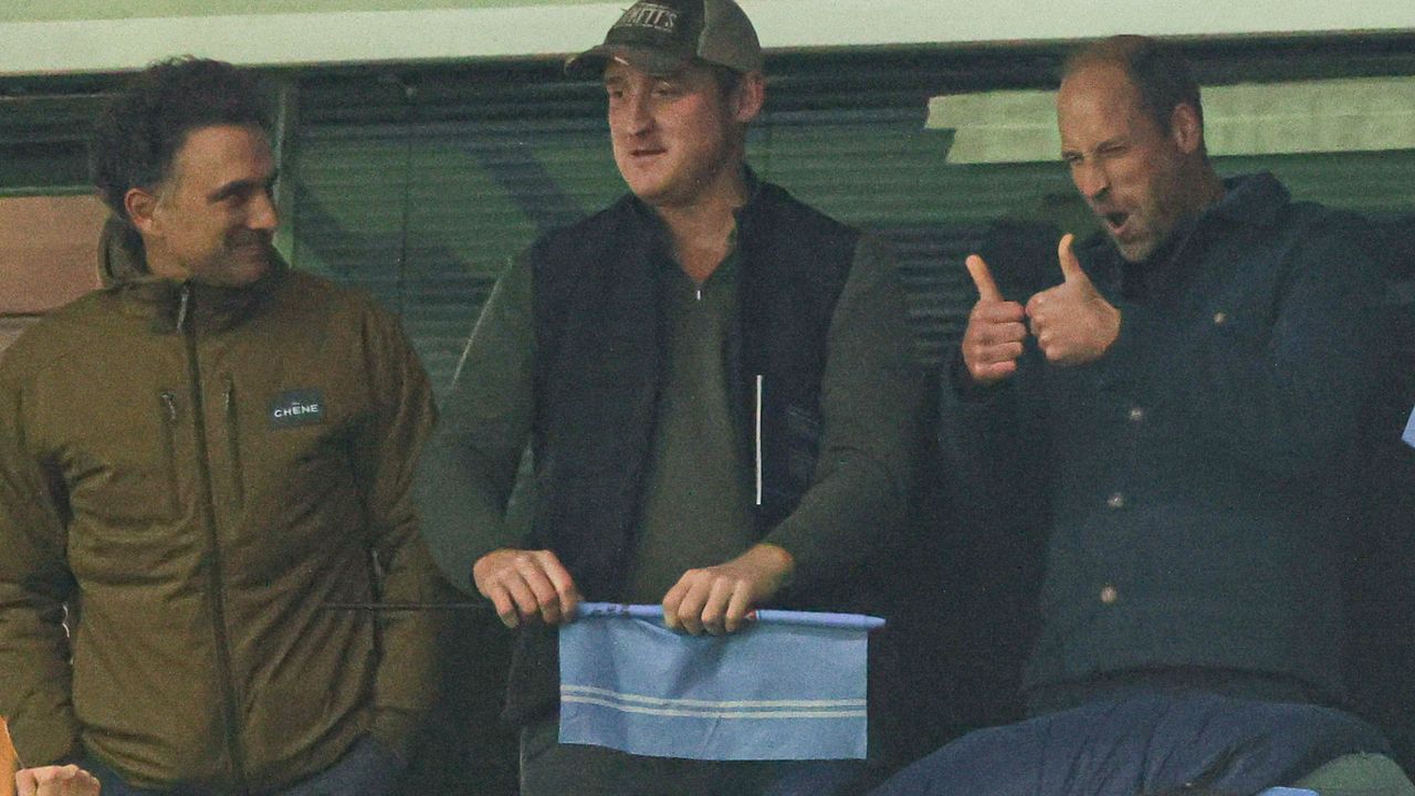 Prince William giving a thumbs up with friends at an Aston Villa match