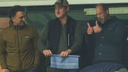 Prince William giving a thumbs up with friends at an Aston Villa match