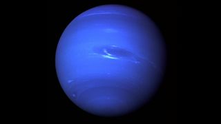 Neptune appears deep blue with wispy light blue bands and a brighter white blue speck in the center of the image.