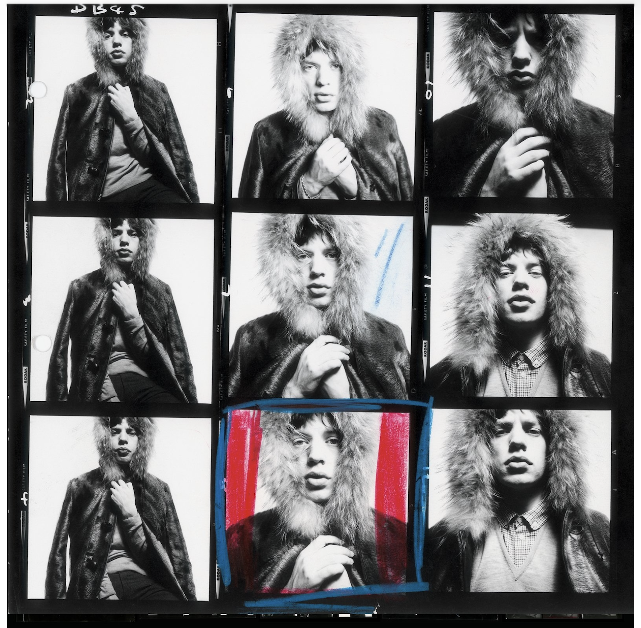 A contact sheet of 12 Mick Jagger portraits in a fur-trimmed coat, with one frame marked in red and blue grease pencil to indicate the selected shot.