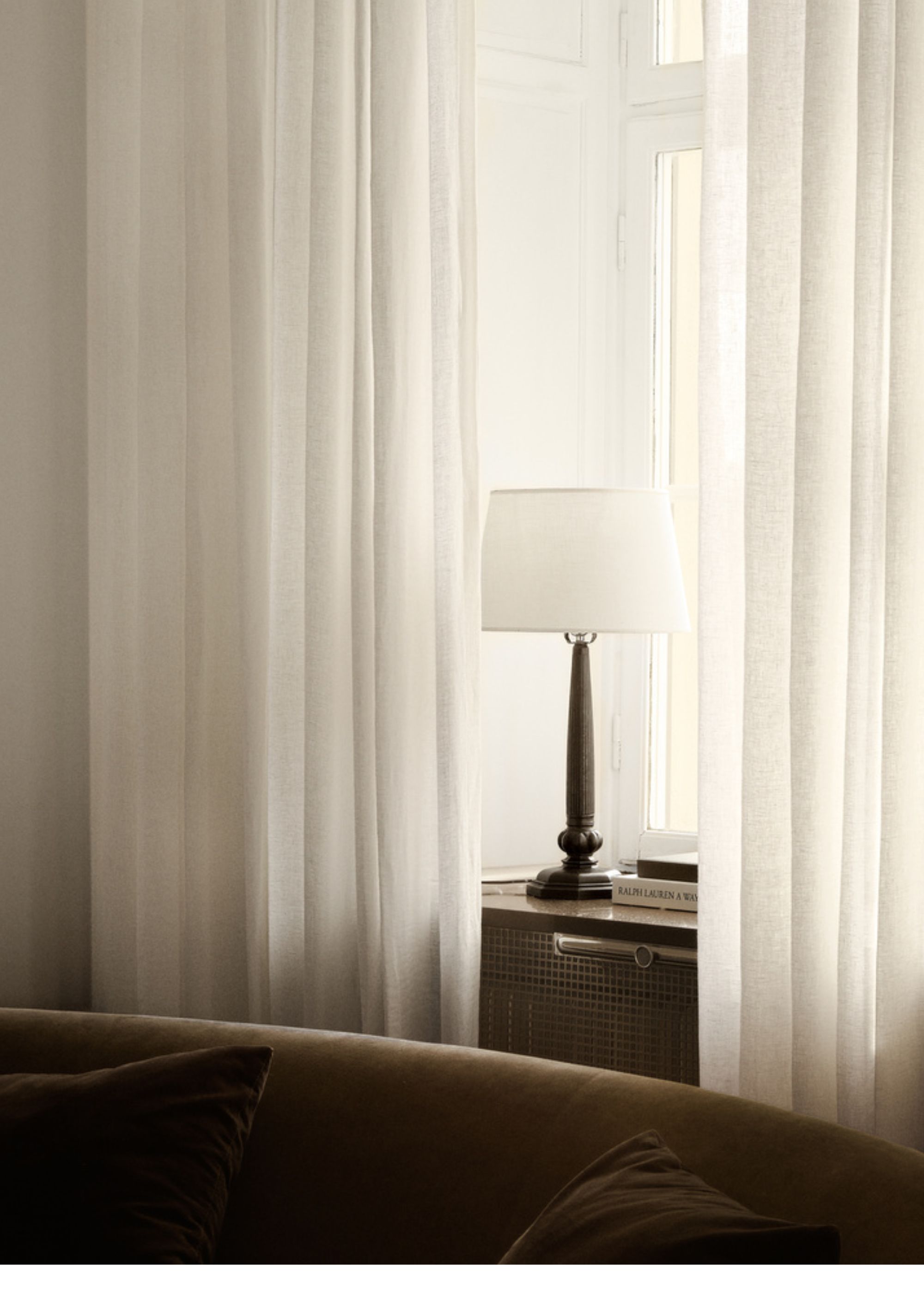 Sheer curtains with a lamp in the middle of it in a living room