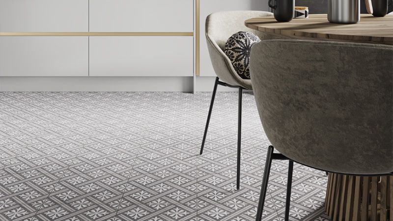 A kitchen with a monochrome tiled floor, and dining table to the right