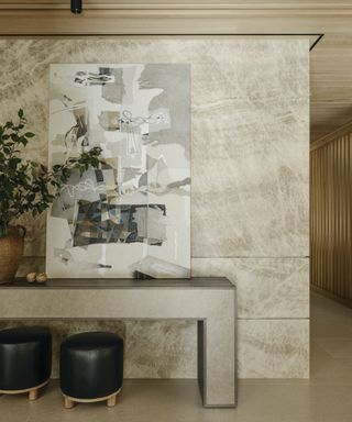 stone feature wall with modern table and two leather stools