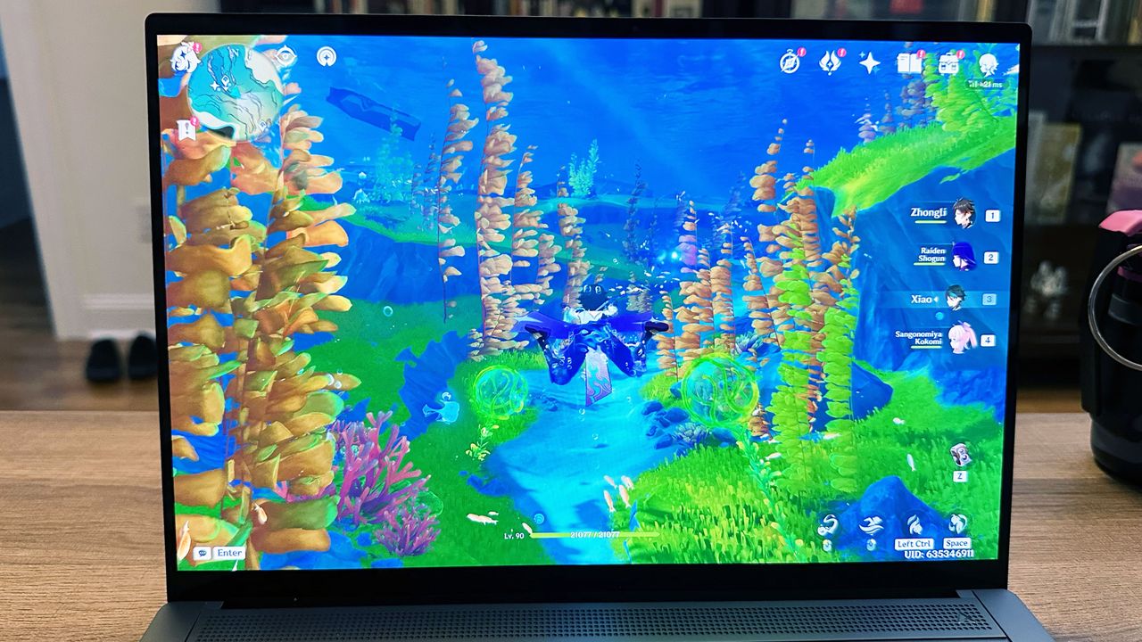 Asus Zenbook S 14 resting on a desk with an underwater scene on the display.
