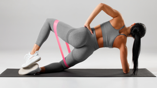 Woman doing plank clamshell exercise