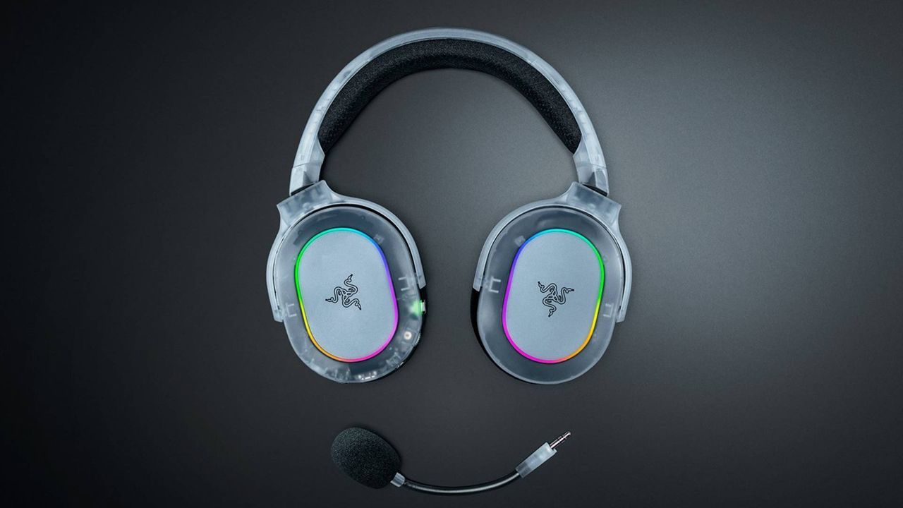 Promo image showing a translucent Razer headset and its detachable microphone sitting on a black table.