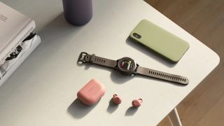 Jabra Elite 8 Active Gen 2 on a table next to a fitness watch and smartphone