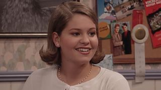 DJ smiling in her room on Full House.