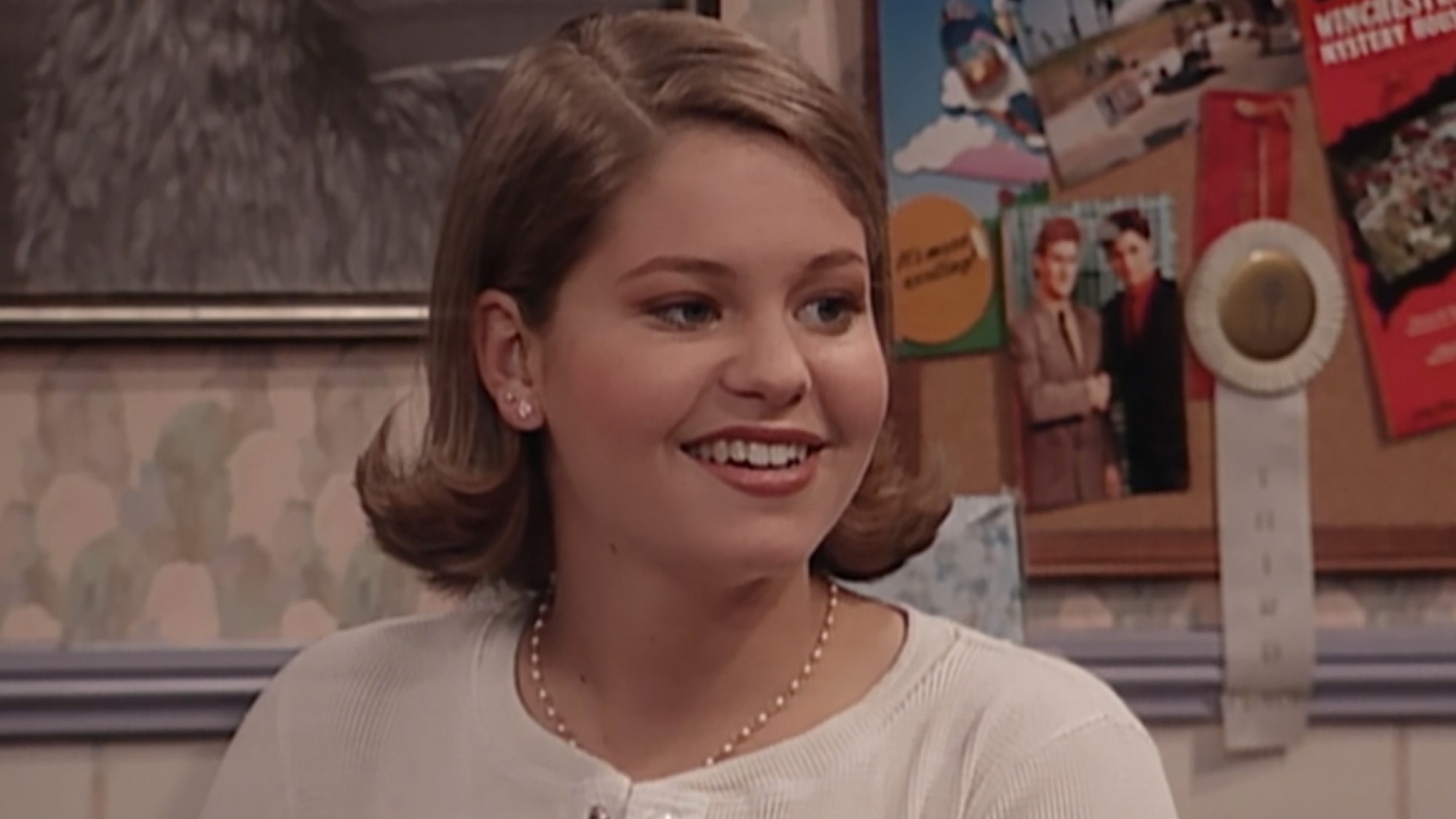 DJ smiling in her room on Full House.